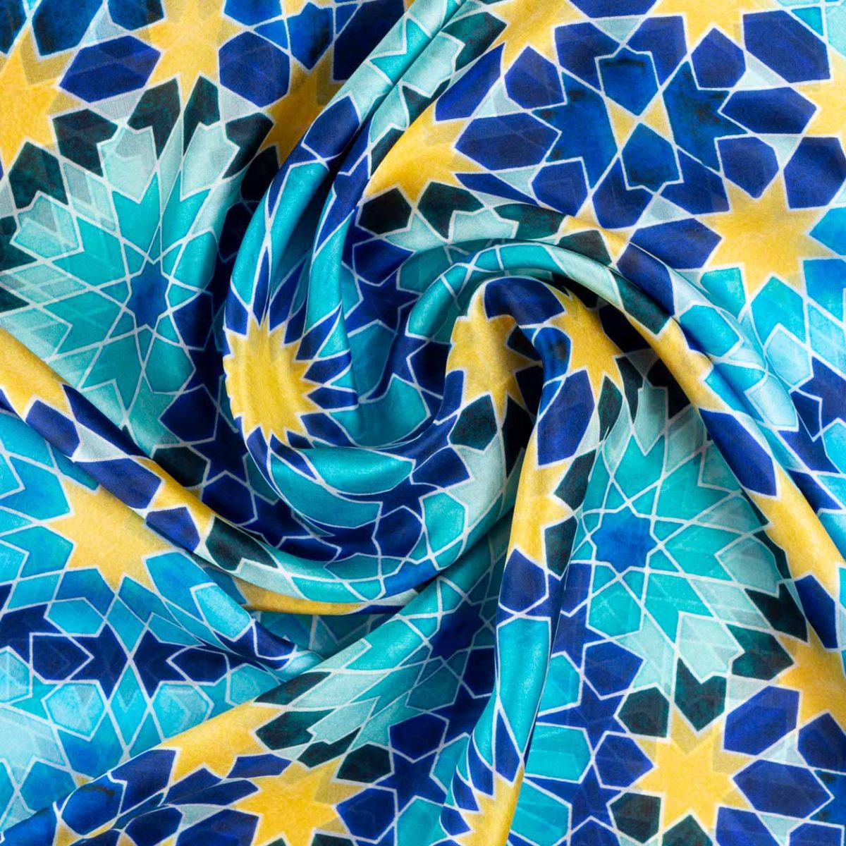 Detalle de pañuelo de seda azul y amarillo con estampado geométrico