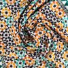 Detalle de pañuelo de seda con estampado geométrico verde y naranja